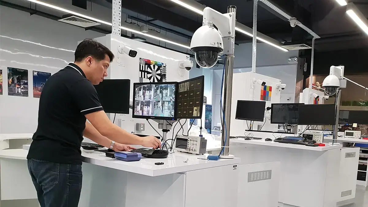 A professional technician testing a PTZ camera and monitoring security feeds in a high-tech CCTV training facility in the Philippines