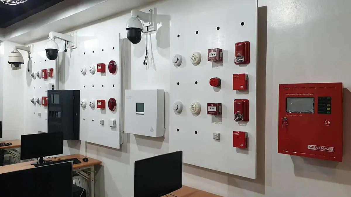 A professional technical training room in the Philippines equipped with fire alarm control panels, smoke detectors, and integrated CCTV systems for FDAS courses.