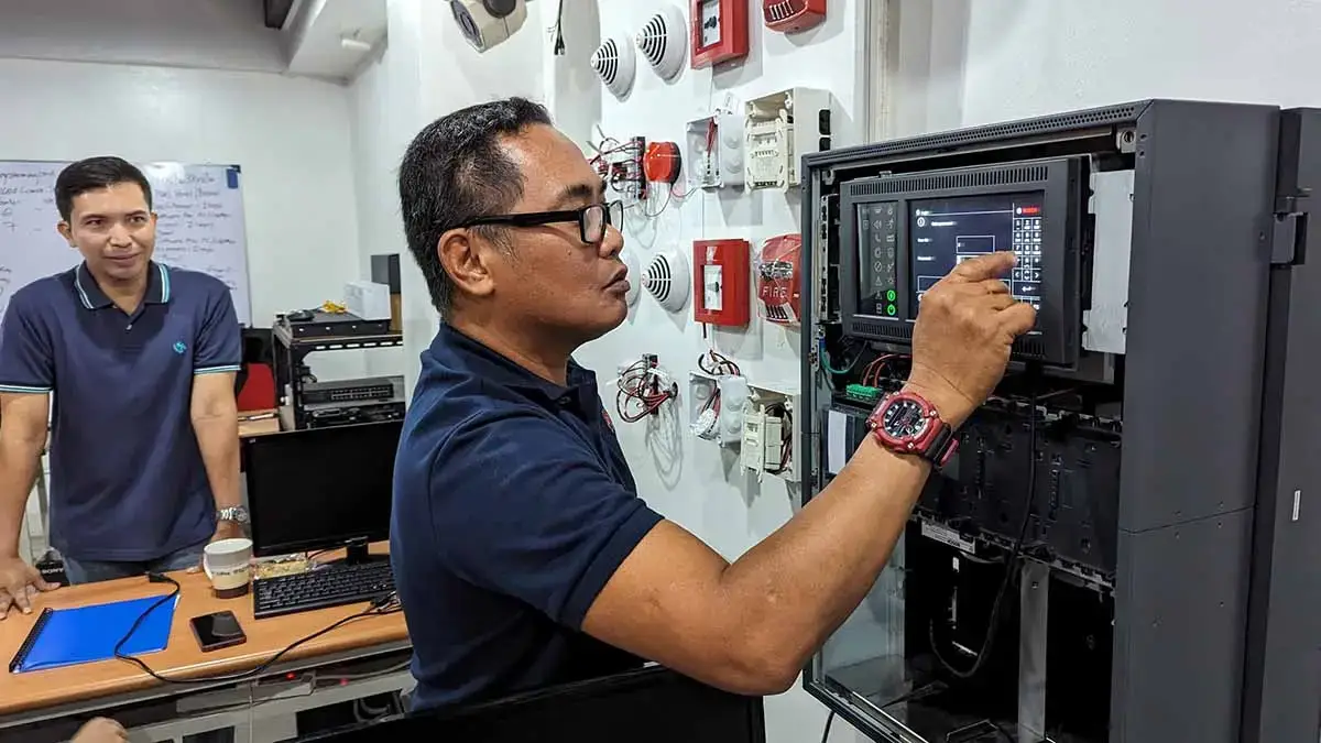 A trainer demonstrating how to program and operate a Bosch Fire Alarm Control Panel during a technical FDAS workshop in the Philippines.